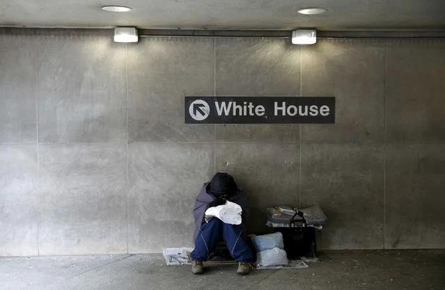 On an unseasonably cold day, a homeless person tries to stay warm at the entrance of a subway station near the White House in Washington January 20,  2016. (Photo by Kevin Lamarque/Reuters)