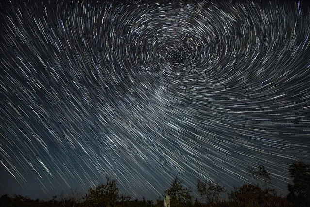 Photomontage taken on September 1, 2021 shows the star trails over the Wudalianchi Geopark in Heihe, northeast China's Heilongjiang Province. The Wudalianchi Geopark is famous for its volcanoes and hot springs. It has 14 volcanoes and five major volcanic barrier lakes. (Photo by Xinhua News Agency/Rex Features/Shutterstock)