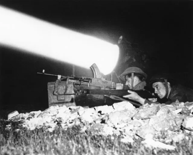With a searchlight beam piercing through the night, a machine gunner and a rifleman are on alert as the British Canadian offensive drive continues, in July 1944, south of Caen, in the Normandy region of France. The D-Day invasion that helped change the course of World War II was unprecedented in scale and audacity. Veterans and world dignitaries are commemorating the 79th anniversary of the operation. (Photo by Pool via AP Photo)