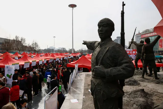 A statue of People's Liberation Army soldiers is seen at a job fair for college graduates and the general public in the centre of Shijiazhuang, Hebei province, China, February 6, 2017. (Photo by Thomas Peter/Reuters)