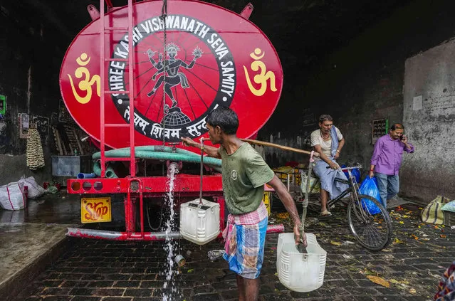 A water vendor fetches water from a mobile water tanker in Kolkata, India, Thursday, February 22, 2024. (Photo by Bikas Das/AP Photo)