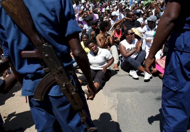 Woman sit in front of police during a protest by women against president Pierre Nkurunziza in Bujumbura, Burundi, May 10, 2015. (Photo by Goran Tomasevic/Reuters)