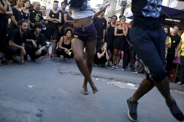 Youths watch dancers performing Passinho, or “little step”, during an event organized by Amnesty International in Rio de Janeiro May 9, 2015. (Photo by Pilar Olivares/Reuters)
