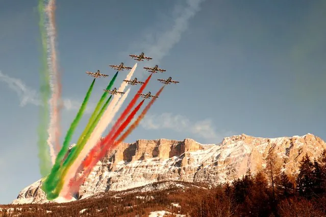 Planes of the Italian Air Force aerobatic unit Frecce Tricolori (Tricolor Arrows) spread smoke with the colors of the Italian flag as they perform over Alta Badia, Dolomite Alps, on December 19, 2021 within the men's FIS Ski World Cup Giant Slalom event. (Photo by Alessandro Garofalo/Reuters)