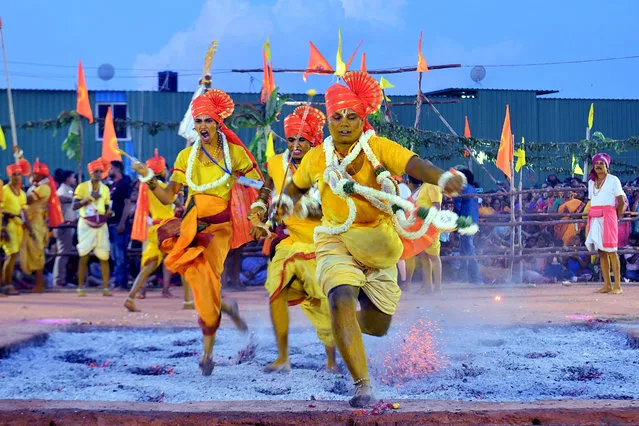 Hindu devotees run through red hot embers as part of annual fire walking ritual during “Draupadi Amman” festival in Bangalore on June 9, 2019. (Photo by Manjunath Kiran/AFP Photo)