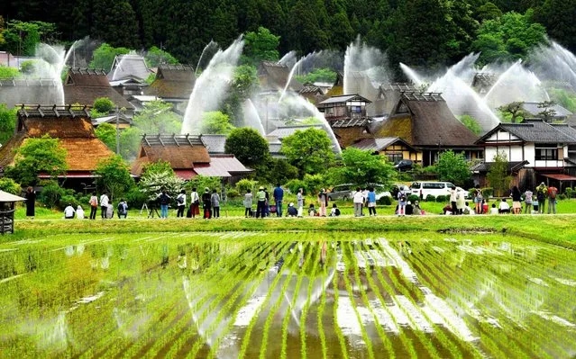 Water are discharged during a biannual fire exercise at Kayabuki no Sato, thatched roof farmhouses on May 20, 2019 in Nantan, Kyoto, Japan. (Photo by The Asahi Shimbun via Getty Images)