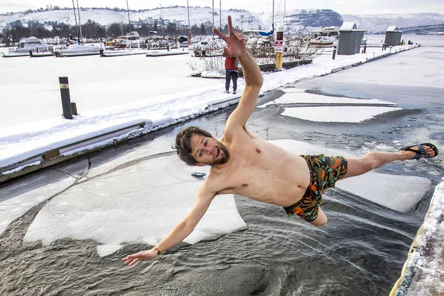 Carey Williams leaps into the icy waters of the Snake River for the 2022 Polar Plunge at the Hells Gate Marina on Saturday, January 1, 2022, in Clarkston, Wash. (Photo by August Frank/Lewiston Tribune via AP Photo)