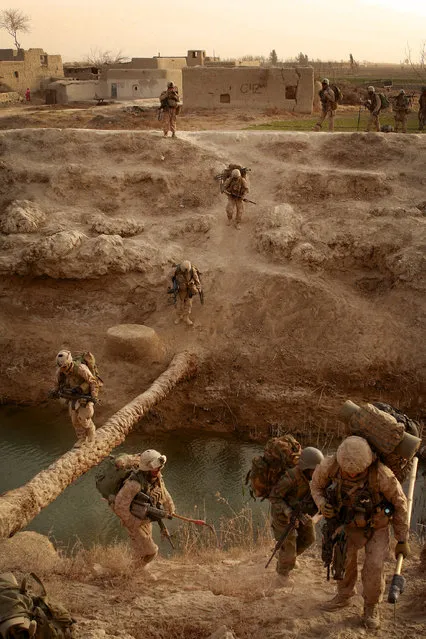 U.S. Marines with Echo Company, 2nd Battalion, 1st Marine Regiment (2/1,) Regimental Combat Team 1, and Afghan National Army (ANA) soldiers cross a makeshift bridge during Operation Godfather in Durzay, Afghanistan, January 14, 2011. (Photo by Sgt. Christopher R. Rye/2nd Battalion, 1st Marine Regiment)