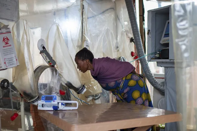 In this Saturday, July 13, 2019 photo, a woman visits a sick relative kept inside an isolation cube at an Ebola treatment center in Beni, Congo. The World Health Organization has declared the Ebola outbreak an international emergency. (Photo by Jerome Delay/AP Photo)