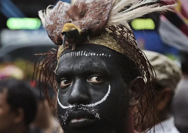 A Papuan activist donning a traditional headwear with a stuffed bird of paradise attends a protest against U.S. mining giant Freeport-McMoRan Copper & Gold Inc. in Jakarta, Indonesia, Monday, March 20, 2017. A group of activists staged the protest demanding the New Orleans-based mining company close its mine in Papua province saying that it siphons off the region's wealth and gives it little in return. (Photo by Achmad Ibrahim/AP Photo)