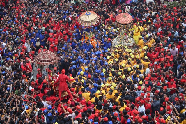 People from Newari community carry chariots of three Goddesses Kankeshwori, Bhadrakali and Sankata wearing colorful caps during the chariot festival at Ason in Kathmandu, Nepal on April 9, 2024. The festival is celebrated every year by Newar community a day after Ghodejatra to conclude the three-day long “Pahan Chahre” festival, which is one of the religious festivals of Nepal celebrated with particular fervor in Kathmandu. (Photo by Sunil Sharma/ZUMA Press Wire/Rex Features/Shutterstock)