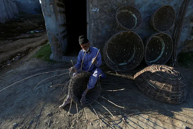 A man uses sticks to make a basket along a road in Islamabad, Pakistan February 9, 2017. (Photo by Fayaz Aziz/Reuters)