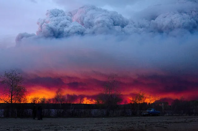 A wildfire moves towards the town of Anzac from Fort McMurray, Alberta., on Wednesday May 4, 2016. Alberta declared a state of emergency Wednesday as crews frantically held back wind-whipped wildfires. Unseasonably hot temperatures combined with dry conditions have transformed the boreal forest in much of Alberta into a tinder box. (Photo by Jason Franson/The Canadian Press via AP Photo)