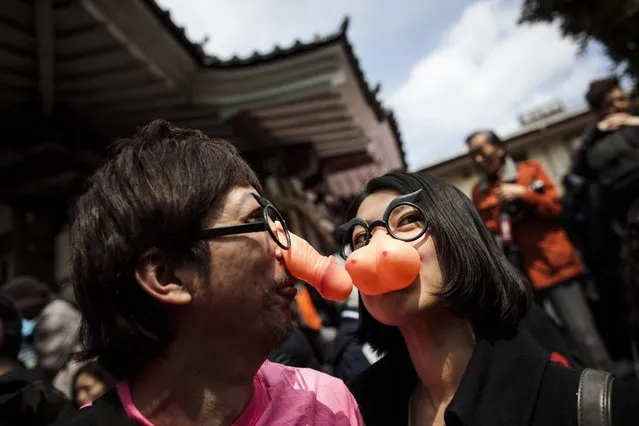 A couple wear plastic noses in the shape of a pen*s and breasts during the Kanamara Festival at Kanayama Shrine in Kawasaki on April 2, 2017. (Photo by Behrouz Mehri/AFP Photo)