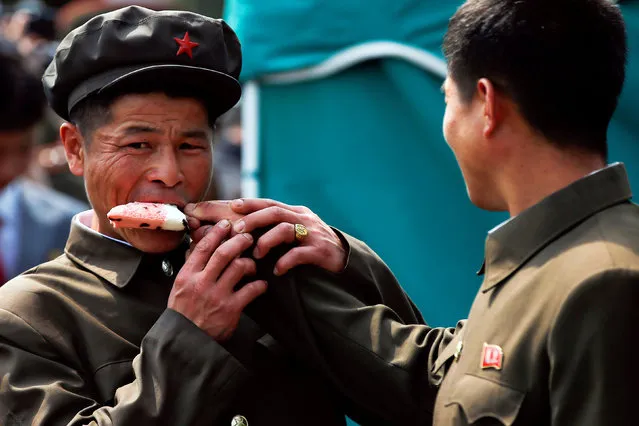 Men share an ice-cream in Pyongyang, North Korea April 16, 2017. (Photo by Damir Sagolj/Reuters)