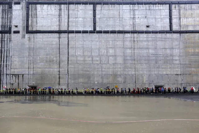 Visitors brave the rain during a tour organized by the Panama Canal to the expansion project in Panama City May 17, 2015. (Photo by Carlos Jasso/Reuters)