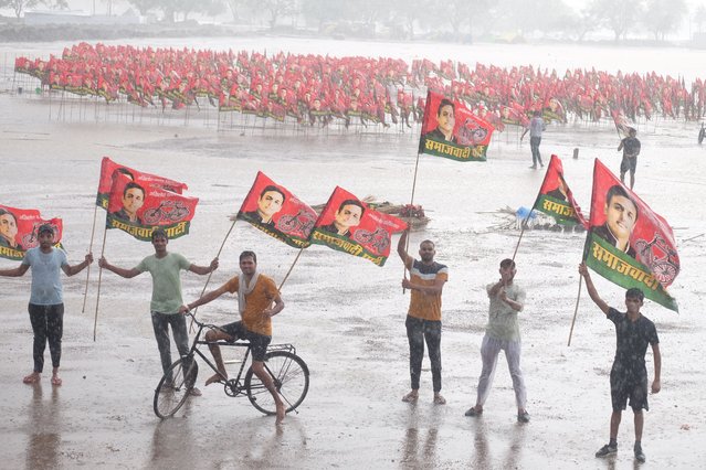 Despite their preparations being ruined due to rain, young people wave flags as part of birthday celebrations for the president of the Samajwadi party, Shree Akhilesh Yadav in Uttar Pradesh, India on June 30, 2024. (Photo by Shashi Sharma/Pacific Press/Rex Features/Shutterstock)