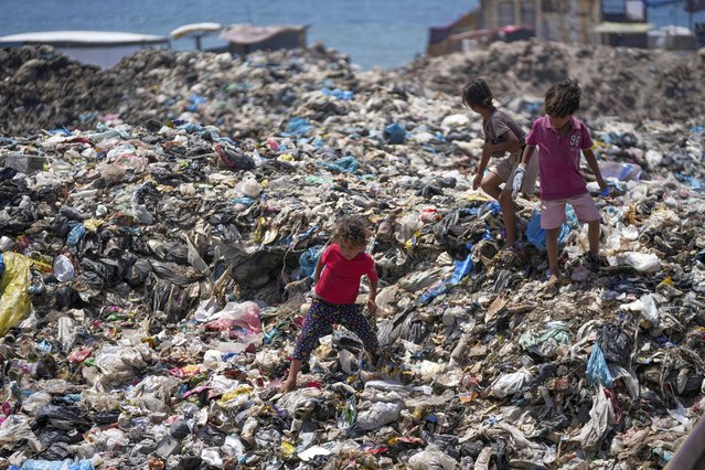 Palestinian kids sort through trash at a landfill in Nuseirat refugee camp, Gaza Strip, Thursday, June 20, 2024. Israel's war in Gaza has decimated the strip's sanitation system while simultaneously displacing the vast majority of the population, leaving many Palestinians living in tent camps nearby water contaminated with sewage and growing piles of garbage. (Photo by Abdel Kareem Hana/AP Photo)