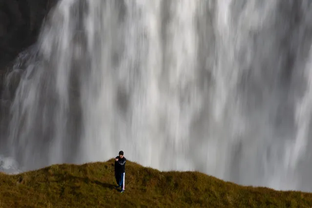 A tourist takes a selfie photograph in an area forbidden to walking, overlooking the waterfalls in Gullfoss, Iceland on September 16, 2019. (Photo by Chris Helgren/Reuters)