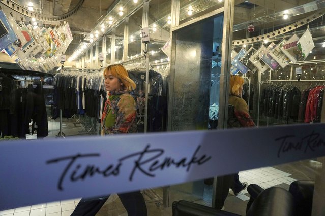 A worker walks around in a store for Times Remake, a Shanghai-based brand that takes secondhand clothes and refashions them into new garments in Shanghai on March 18, 2024. (Photo by Ng Han Guan/AP Photo)