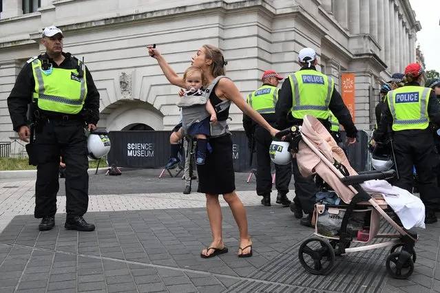 A woman carrying a baby argues with the police as she takes part in an anti-vaccination protest outside the Science museum on September 3, 2021 in London, England. The anti-vaccination protesters have gathered in London following the Medicines and Healthcare products Regulatory Agency’s decision to approve the Pfizer COVID-19 vaccine for use on children between the ages of 12 and 15. This afternoon it was announced that the Joint Committee on Vaccination and Immunisation (JCVI) will not recommend the mass vaccination of children in the UK. (Photo by Chris J. Ratcliffe/Getty Images)