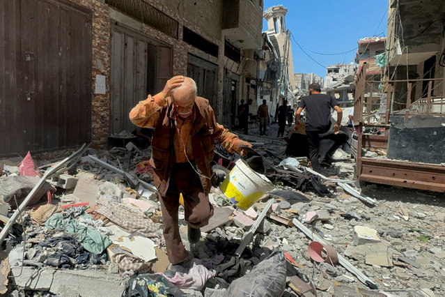 A Palestinian man walks near an apartment hit in an Israeli strike, amid Israel-Hamas conflict, in Gaza City, on August 26, 2024. (Photo by Ayman Al Hassi/Reuters)