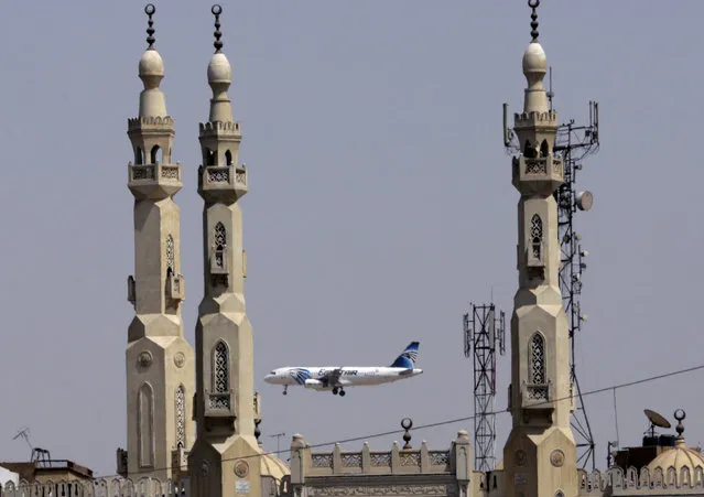 In this May 21, 2016 file photo, an EgyptAir plane flies past minarets of a mosque as it approaches Cairo International Airport, in Cairo, Egypt. Egyptians officials say a bomb threat has forced an EgyptAir airliner en route to Beijing from Cairo to make an emergency landing in Uzbekistan, where the aircraft is being searched. (Photo by Amr Nabil/AP Photo)
