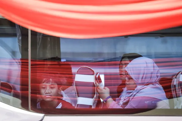 Relatives of passengers who died on Lion Air flight 610 plane crash ride on a bus as they leave Tanjung Priok port shortly after attending one year commemoration of the accident in Jakarta, Indonesia, 29 October 2019. A number of 189 people lost their lives during the crash. (Photo by Mast Irham/EPA/EFE)