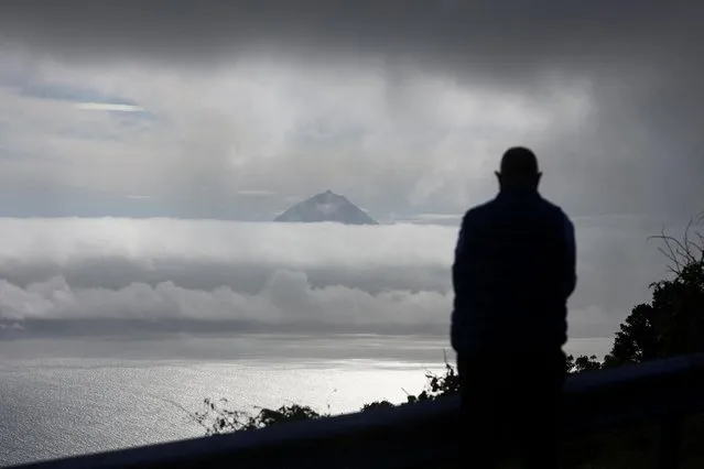 A person watches Pico island from Calheta as small earthquakes have been recorded in Sao Jorge island, Azores, Portugal, March 29, 2022. (Photo by Pedro Nunes/Reuters)