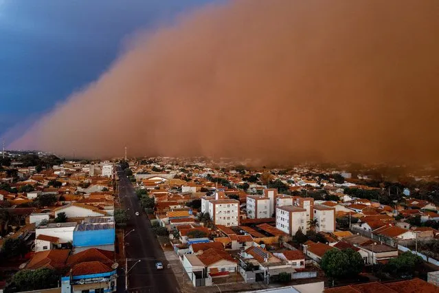 A massive dust storm is seen engulfing the neighbourhood of Nossa Senhora do Carmo at the city of Frutal, Minas Gerais state, Brazil, on September 26, 2021. The dust storm was seen in several cities of the states of Sao Paulo and Minas Gerais, southeast region of Brazil, followed by heavy rains that spread damages in the region. (Photo by Andrey Luz/AFP Photo)