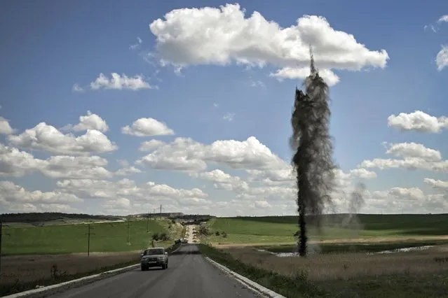A mortar explodes next to the road leading to the city of Lysychansk in the eastern Ukranian region of Donbas, on May 23, 2022, amid Russian invasion of Ukraine. (Photo by Aris Messinis/AFP Photo)
