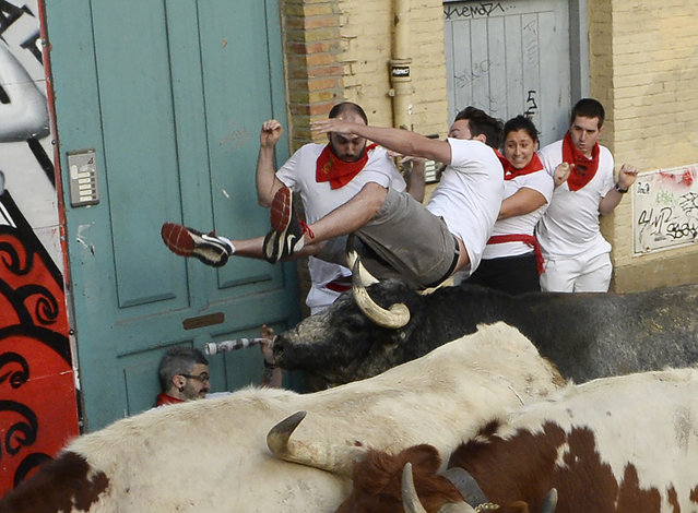 A participant is tossed by a Cebada Gago fighting bull on the first day of the San Fermin bull run festival in Pamplona, northern Spain on July 7, 2017. (Photo by Ander Gillenea/AFP Photo)