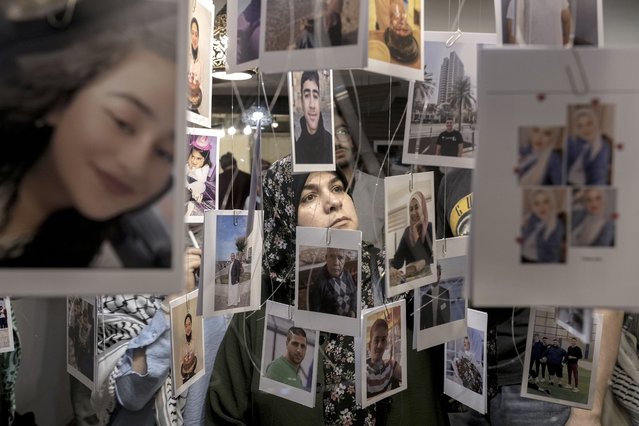 A woman views photos of Palestinian victims who were killed during the Israel war against Hamas, at a photo exhibition, (Gaza Habibti), Gaza my love, to commemorate the one-year anniversary of the war in the Gaza Strip, in Cairo, Egypt, Monday, October 7, 2024. (Photo by Amr Nabil/AP Photo)