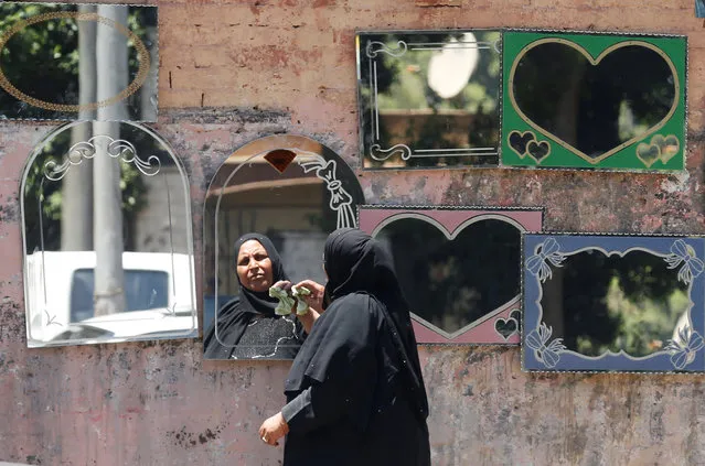 An Egyptian woman cleans her mirrors for sale on the street near the Nile island of al-Warraq, one day after security forces clashed with residents while attempting to demolish illegal buildings, in the south of Cairo, Egypt July 17, 2017. (Photo by Amr Abdallah Dalsh/Reuters)
