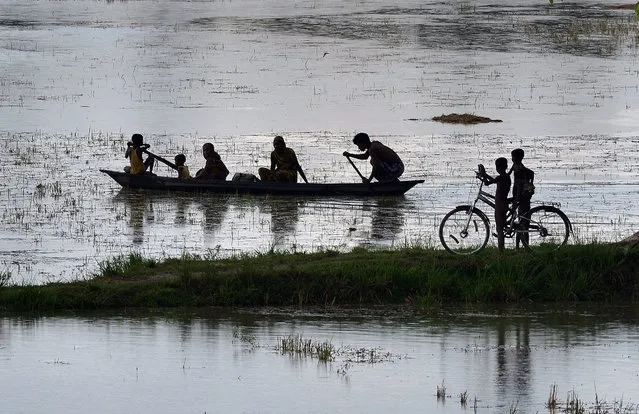 Indian villagers wade through the rain water at  Morigaon district of Assam state, India, 24 June 2016. Its been a continuous rain in the past days in most part of Assam disturbing the life in the villages. (Photo by EPA/Stringer)