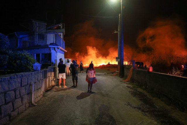 People watch a wildfire in Canas de Senhorim, Portugal on September 16, 2024. (Photo by Pedro Nunes/Reuters)