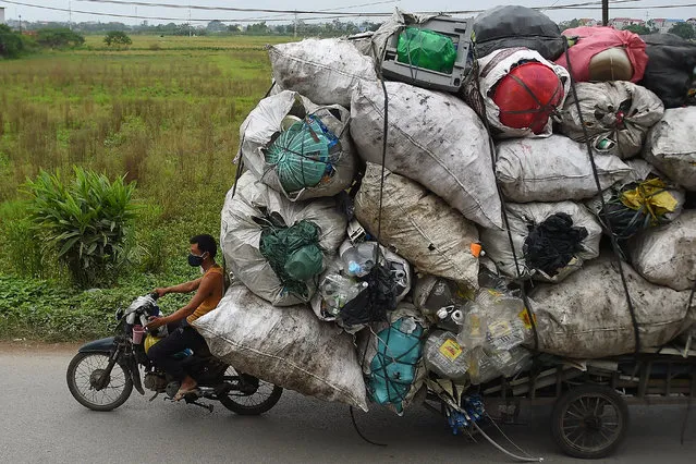 Waste collectors transport plastic scrap for recycling in the suburbs of Hanoi on October 15, 2019. (Photo by Nhac Nguyen/AFP Photo)