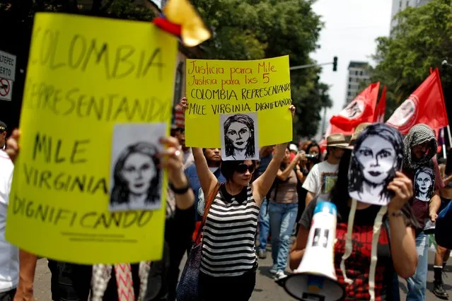 Demonstrators hold masks of Colombian citizen Mile Virginia, who was murdered along with photojournalist Ruben Espinosa and three other women, during a protest in Mexico City, August 16, 2015. The placards read, “Justice for Mile, Justice for the 5” and “Representing Colombia, Dignifying Mile Virginia” (L). (Photo by Tomas Bravo/Reuters)