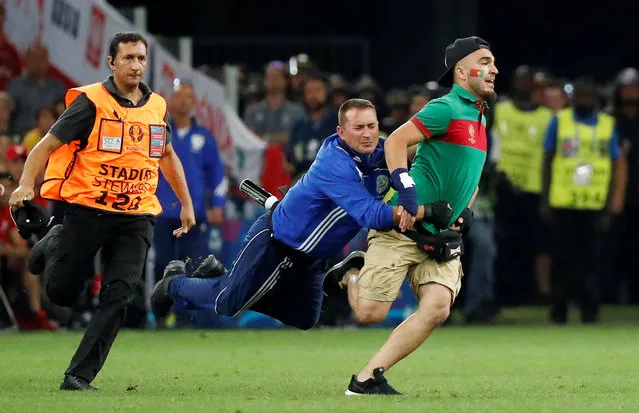 Football Soccer, Poland vs Portugal, EURO 2016, Quarter Final, Stade Velodrome, Marseille, France on June 30, 2016. Security tackle a pitch invader. (Photo by Christian Hartmann/Reuters/Livepic)