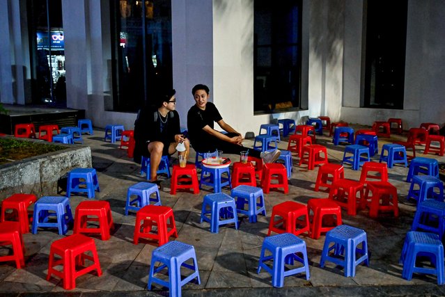 Customers enjoy drinks at a cafe terrace set up on a sidewalk in Hanoi on October 30, 2024. (Photo by Nhac Nguyen/AFP Photo)