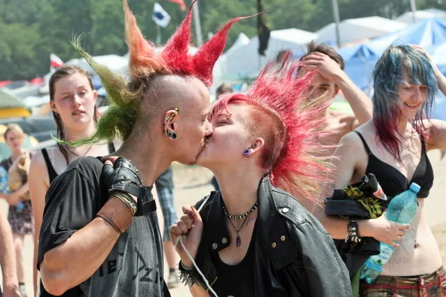 Festival-goers kiss as they arrive to the campsite of the 20th Przystanek Woodstock (Woodstock Bus Stop) in Kostrzyn on the Odra River, Poland, July 29, 2014. The open air event with free entrance will run from 31 July to 02 August. (Photo by Lech Muszynski/EPA)