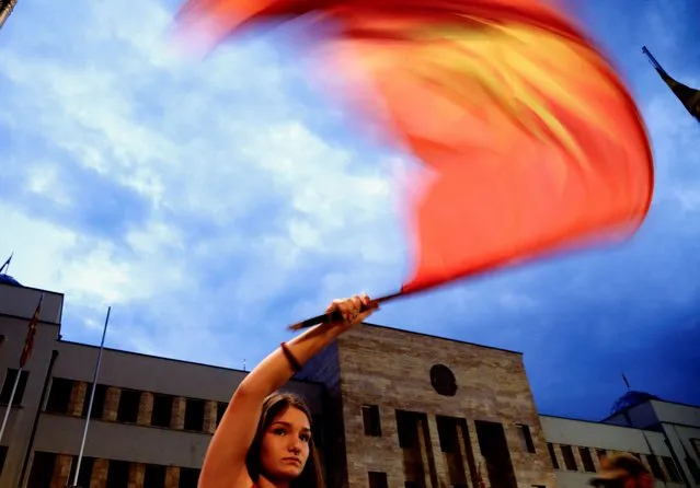 A supporter of VMRO-DPMNE, North Macedonia's biggest opposition party, waves a flag while rallying in Skopje, North Macedonia on July 10, 2022. (Photo by Ognen Teofilovski/Reuters)