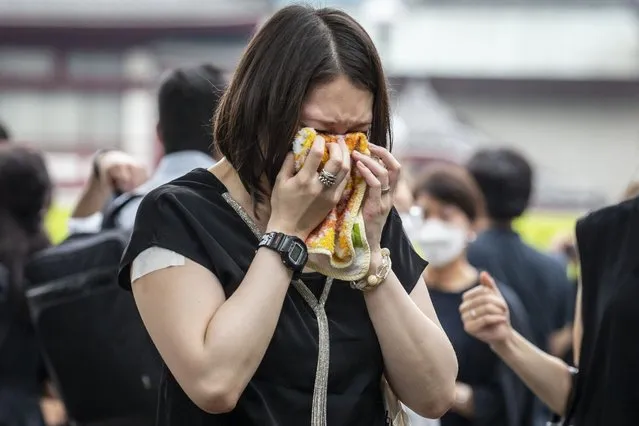 A woman cries after laying flowers at Zojoji temple on the day of the funeral for former Japanese Prime Minister Shinzo Abe on July 12, 2022 in Tokyo, Japan. Abe was assassinated as he was campaigning at a rally in Nara on Friday. A suspect was apprehended and taken into custody, and confessed to shooting Abe with an improvised homemade gun. The killing of Japan's longest-serving prime minister in a country where gun violence is extremely rare has shocked the nation and the world. (Photo by Yuichi Yamazaki/Getty Images)
