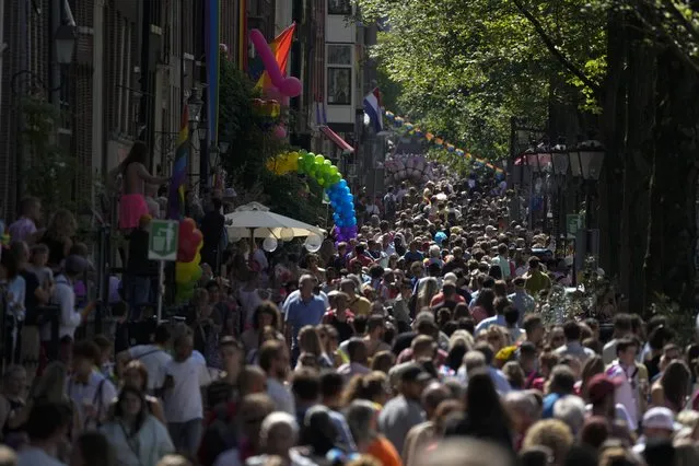 Hundreds of thousands of people lined canals in the Dutch capital to watch the colorful spectacle of the Pride Canal Parade return for the 25th edition after the last two events were canceled due to the COVID-19 pandemic, in Amsterdam, Netherlands, Saturday, August 6, 2022. (Photo by Peter Dejong/AP Photo)