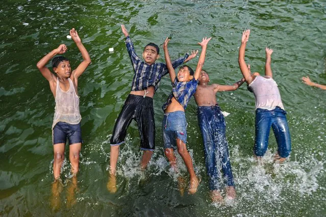 Children play in a pond during high-temperature weather in Sylhet, Bangladesh on July 21, 2022. (Photo by Md Rafayat Haque Khan/ZUMA Press Wire)