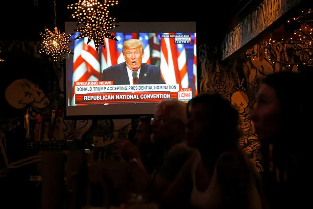 Patrons in the Barrio restaurant watch Republican presidential nominee Donald Trump deliver his speech at the Republican National Convention in Cleveland, Ohio, U.S., July 21, 2016. (Photo by Andrew Kelly/Reuters)