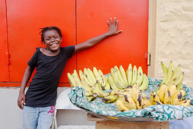 A young street vendor smiles in front of a closed shop in Monrovia, Liberia, July 5, 2016. (Photo by Thierry Gouegnon/Reuters)