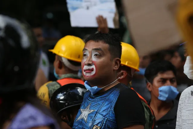 A street clown arrives to help the the recovery and search of victims at a collapsed building after a 7.1 earthquake in Mexico City, Tuesday, September 19, 2017. (Photo by Gustavo Martinez Contreras/AP Photo)