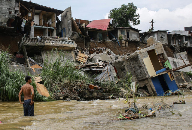 A Filipino resident search for salvageable materials after a dike collapsed in Marikina City, east of Manila, Philippines, 01 September 2015. Local reports said, at least one hundred families were evacuated as scores of houses damaged when heavy rains caused a collapse of a dike nearby. (Photo by Mark R. Cristino/EPA)