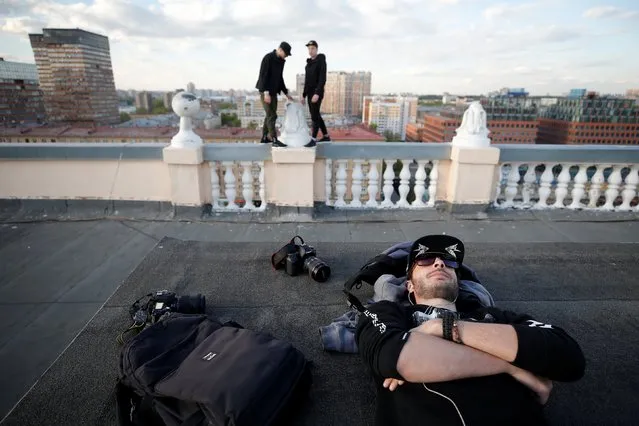 Yevgeny Halkechev of Rudex team rests as his team mates stand on the parapet of a roof in Moscow, Russia, May 13, 2017. (Photo by Maxim Shemetov/Reuters)